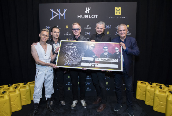 Depeche Mode and Ricardo Guadalupe hand over the check to Scott Harrisson from charity water association